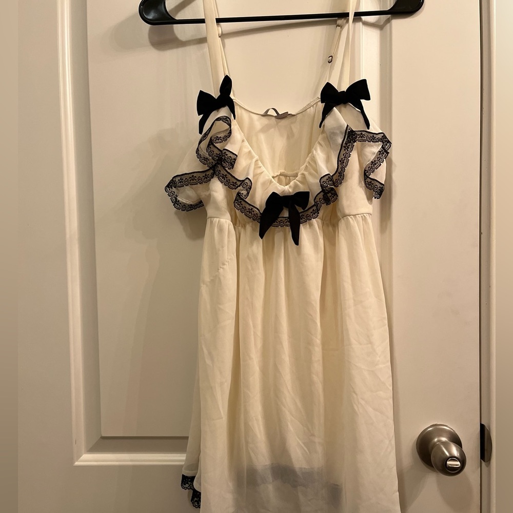 Victorias Secret Size L Sheer cream babydoll with black bow decor.